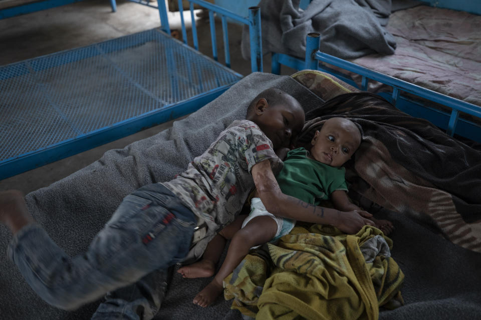 Micheale Gebremariam, un refugiado de Tigray de 5 años, abraza a su hermana de 4 meses Aden en albergue donde vive la familia en Hamdayet, en el este de Sudán, cerca de la frontera con Etiopía, el 21 de marzo de 2021. (AP Foto/Nariman El-Mofty)