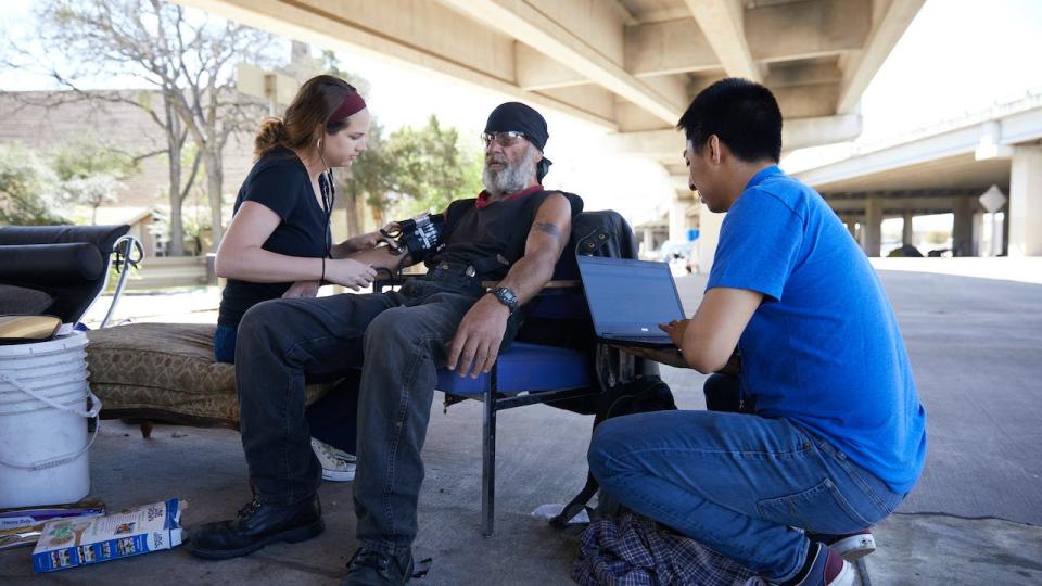 CommUnityCare nurse Taylor Frank and Integral Care social worker Tony Nunez check in with a patient living under an Interstate 35 overpass. Integral Care will soon be able to refer a patient to social services providers with the click of a button and then see if the connection was made later.