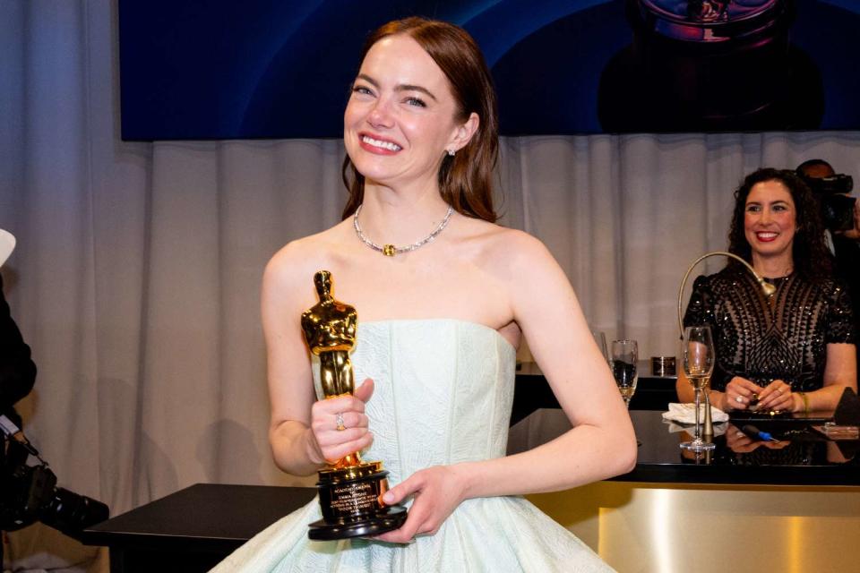 <p>Michael Buckner/Variety via Getty Images</p> Emma Stone holds her Best Actress Oscar for 