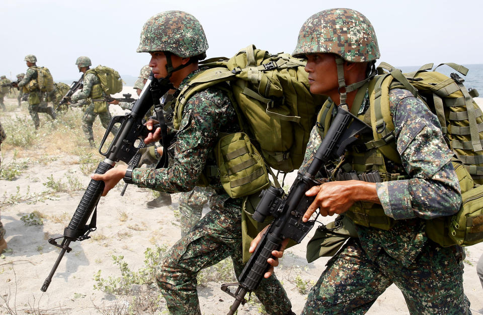 FILE - In this May 9, 2018, file photo, Philippine and U.S. Marines begin their assault after storming the beach during an amphibious landing exercise during the two-week joint U.S.-Philippines military exercise facing the South China Sea in the northwestern Philippines. More than 2,000 U.S. and Philippine military personnel, along with a small contingent of Japanese forces, are holding annual combat exercises aimed at responding rapidly to crises and natural disasters and underscoring their commitment to keeping the region "free and open." (AP Photo/Bullit Marquez, File)