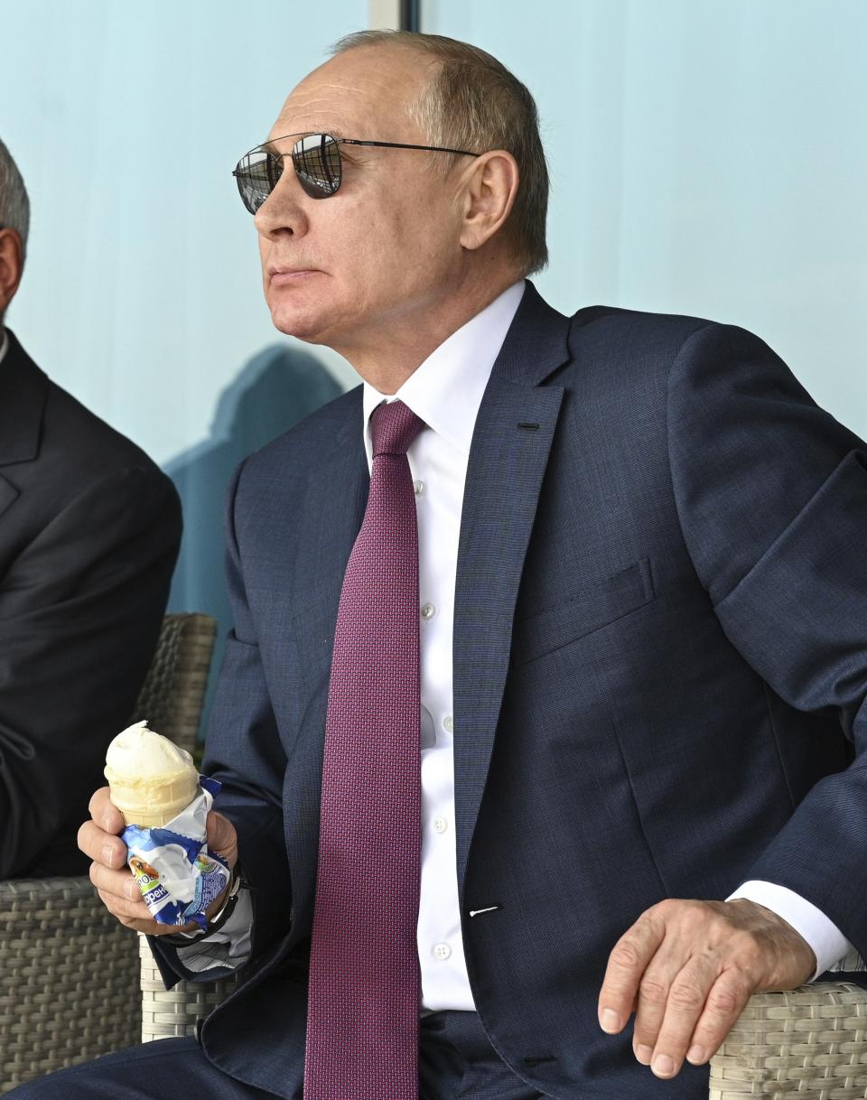 Russian President Vladimir Putin holds an ice-cream as he inspects new models of weapons at the MAKS-2021 International Aviation and Space Salon in Zhukovsky outside Moscow, Russia, Tuesday, July 20, 2021. Russia on Tuesday unveiled a prototype of its prospective new fighter jet at the Moscow air show. (Alexei Nikolsky, Sputnik, Kremlin Pool Photo via AP)