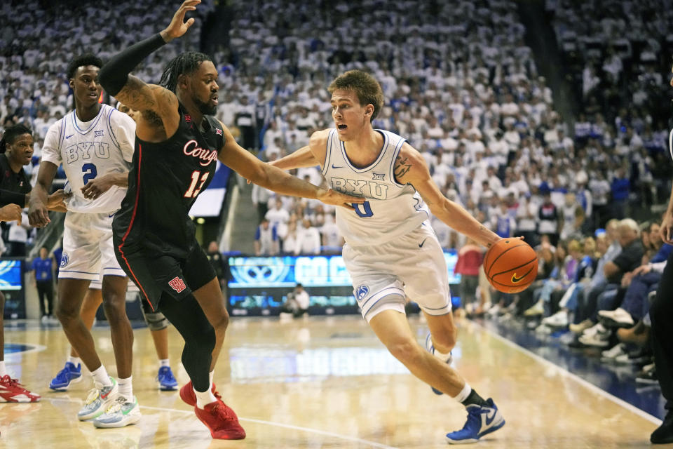 BYU forward Noah Waterman (0) drives as Houston forward J'Wan Roberts (13) defends during the second half of an NCAA college basketball game Tuesday, Jan. 23, 2024, in Provo, Utah. (AP Photo/Rick Bowmer)