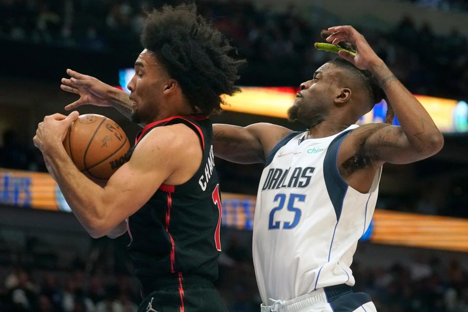 Toronto Raptors forward Justin Champagnie (11) pulls in a rebound against Dallas Mavericks forward Reggie Bullock (25) during the first half of an NBA basketball game in Dallas, Wednesday, Jan. 19, 2022. (AP Photo/LM Otero)