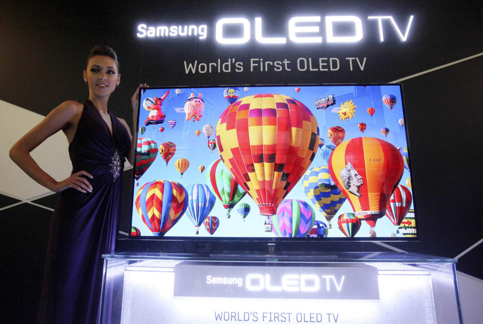 FILE - In this May 10, 2012 file photo, a model poses with a 55-inch Samsung OLED, or organic light-emitting diode, TV during a press conference in Seoul, South Korea. Japan is imposing restrictions on exports to South Korea, citing a decline in "relations of international trust" between the Asian neighbors. South Korea’s Samsung Electronics, the world’s biggest maker of memory chips and smartphones and a major producer of display panels, said it’s assessing how the Japanese import restrictions could possibly influence its business. (AP Photo/Ahn Young-joon, File)