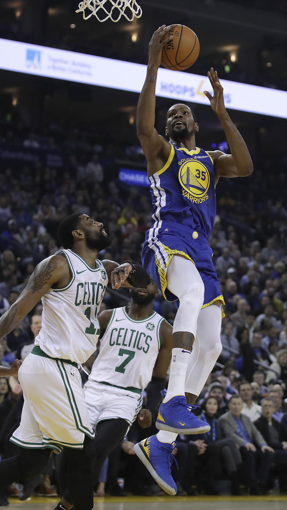 Golden State Warriors' Kevin Durant, right, shoots over Boston Celtics' Kyrie Irving (11) during the first half of an NBA basketball game Tuesday, March 5, 2019, in Oakland, Calif. (AP Photo/Ben Margot)