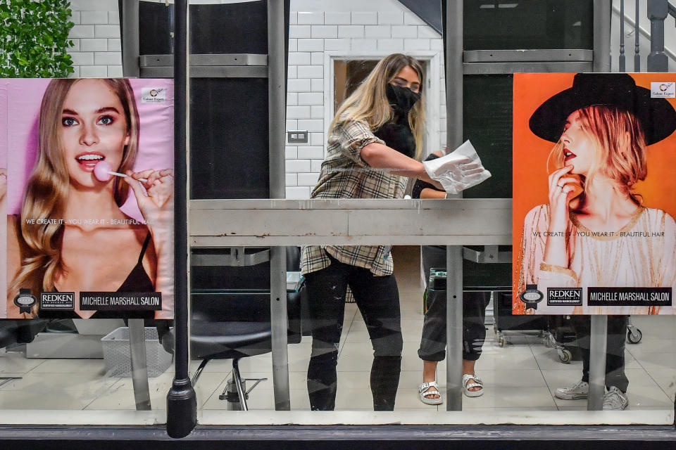 Staff at the Michelle Marshall Salon in Duke St Arcade, Cardiff, clean and disinfect the salon ahead of welcoming back customers. Photo: Ben Birchall/PA via Getty