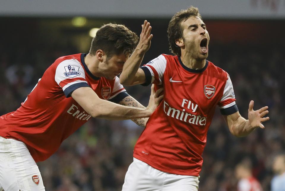 Arsenal's Mathieu Flamini, right, celebrates scoring a goal with Olivier Giroud during the English Premier League soccer match between Arsenal and Manchester City at the Emirates stadium in London, Saturday, March 29, 2014. (AP Photo/Kirsty Wigglesworth)