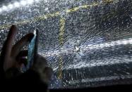 A broken window on an official media bus after it shattered when driving accredited journalists to the Main Transport Mall from the Deodoro venue of the Rio 2016 Olympic Games in Rio de Janeiro, August 9, 2016. REUTERS/Shannon Stapleton