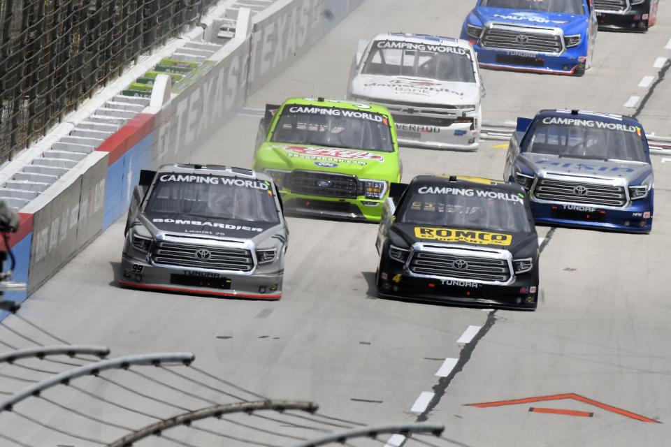 Ben Rhodes, left front, and John Hunter Nemechek, right front, lead the field into Turn 1 during a NASCAR Truck Series auto race at Texas Motor Speedway in Fort Worth, Texas, Saturday, June 12, 2021. (AP Photo/Larry Papke)