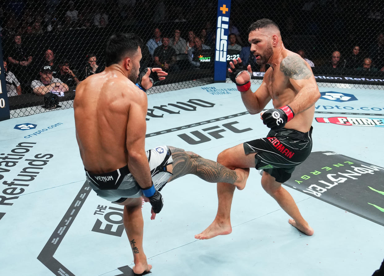 BOSTON, MASSACHUSETTS - AUGUST 19: (L-R) Brad Tavares kicks Chris Weidman in a middleweight fight during the UFC 292 event at TD Garden on August 19, 2023 in Boston, Massachusetts. (Photo by Cooper Neill/Zuffa LLC via Getty Images)