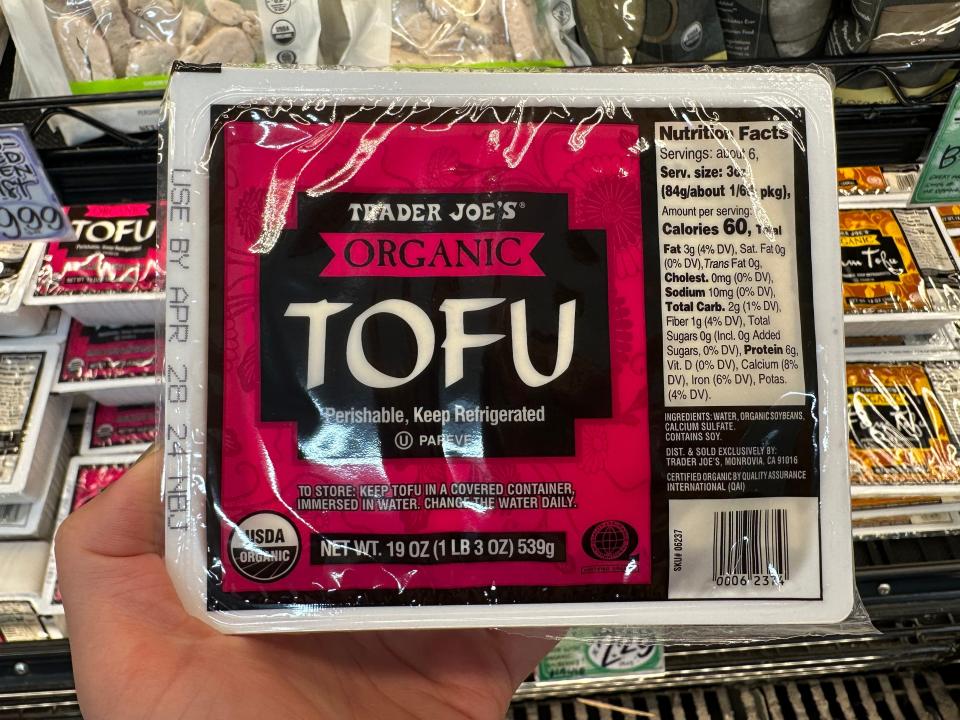 hand holding up a package of trader joe's organic firm tofu