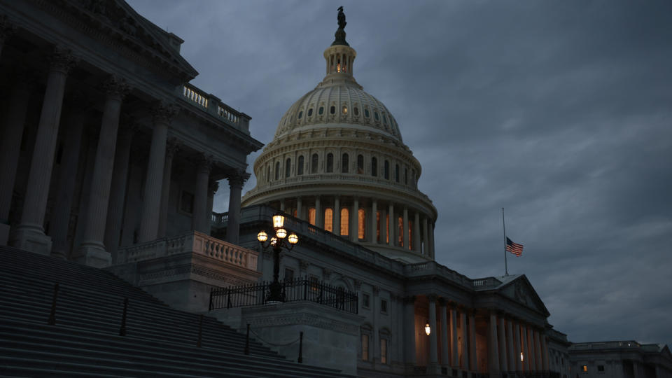 The American flag is flown at half-staff in honor of the late Sen. Bob Dole, R-Kan., at the U.S. Capitol at dusk.