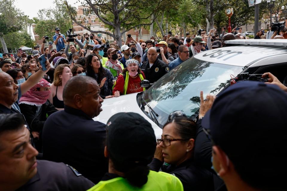 Students and community members clash with USC Public Safety Officers during a Gaza solidarity occupation on campus, with demonstrators blocking a car trying to remove an arrested individual (EPA)