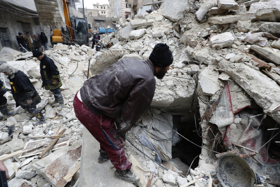 Syrian Civil Defense workers and security forces search through the wreckage of collapsed buildings, in Aleppo, Syria, Monday, Feb. 6, 2023. A powerful earthquake rocked wide swaths of Turkey and neighboring Syria on Monday, toppling hundreds of buildings and killing and injuring thousands of people. (AP Photo/Omar Sanadiki)