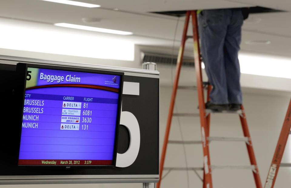 An electrician works in the ceiling next to the baggage claim in the new Maynard Holbrook Jackson Jr. International Terminal at Atlanta's airport Wednesday, March 28, 2012.The new $1.4 billion international terminal at the world's busiest airport will be a sleek launching pad for millions of passengers that’s designed to help Atlanta grab a growing share of the lucrative market for global travelers. (AP Photo/David Goldman)