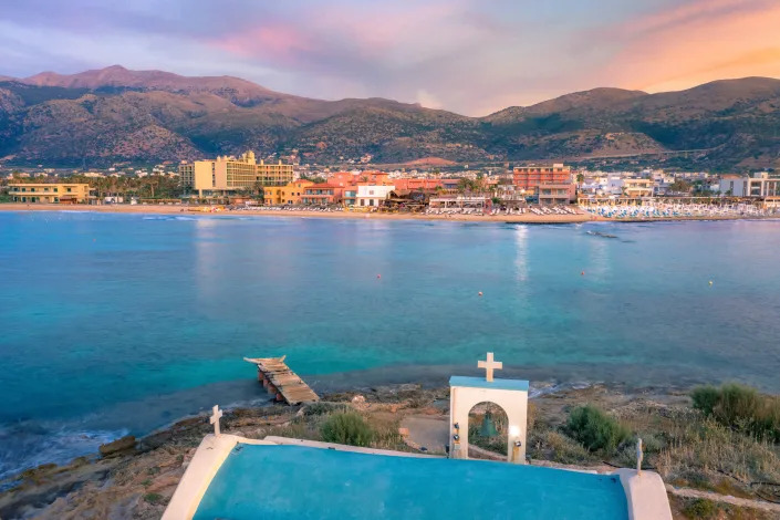 An old white church in a small island at sunset in Malia, Crete, Greece.