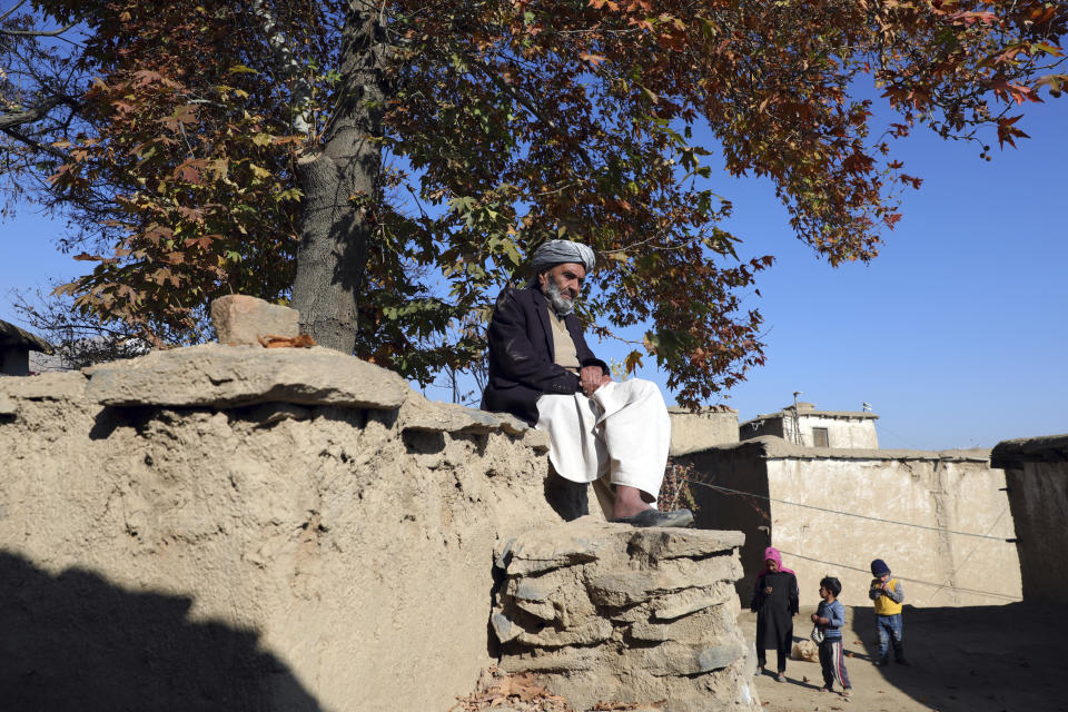 An elderly Afghan man sits in the sun on a cold day in Istalef district of Kabul, Afghanistan, Saturday, Nov. 21, 2020. (AP Photo/Rahmat Gul)