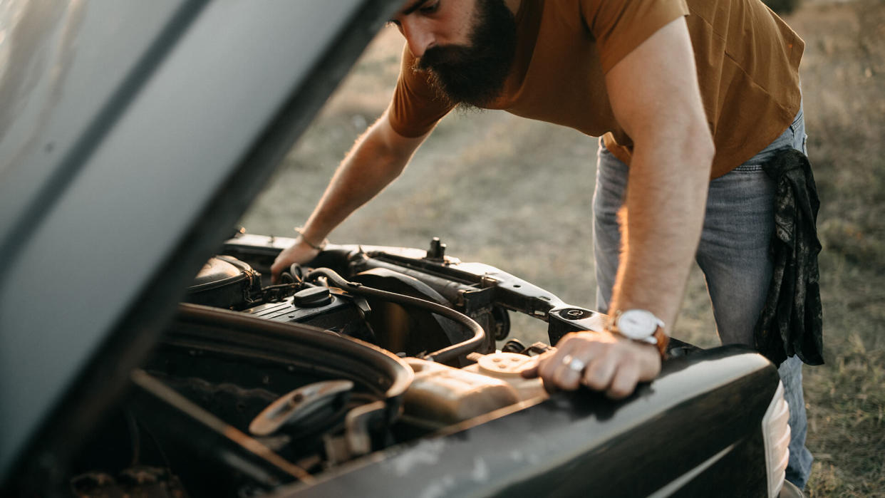 Photo of young man is fixing his car.