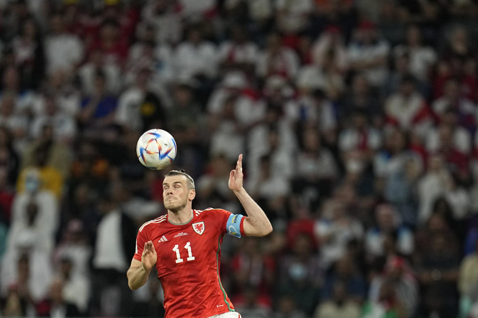 Wales' Gareth Bale goes for a header during the World Cup group B soccer match between England and Wales, at the Ahmad Bin Ali Stadium in Al Rayyan , Qatar, Tuesday, Nov. 29, 2022. (AP Photo/Abbie Parr)