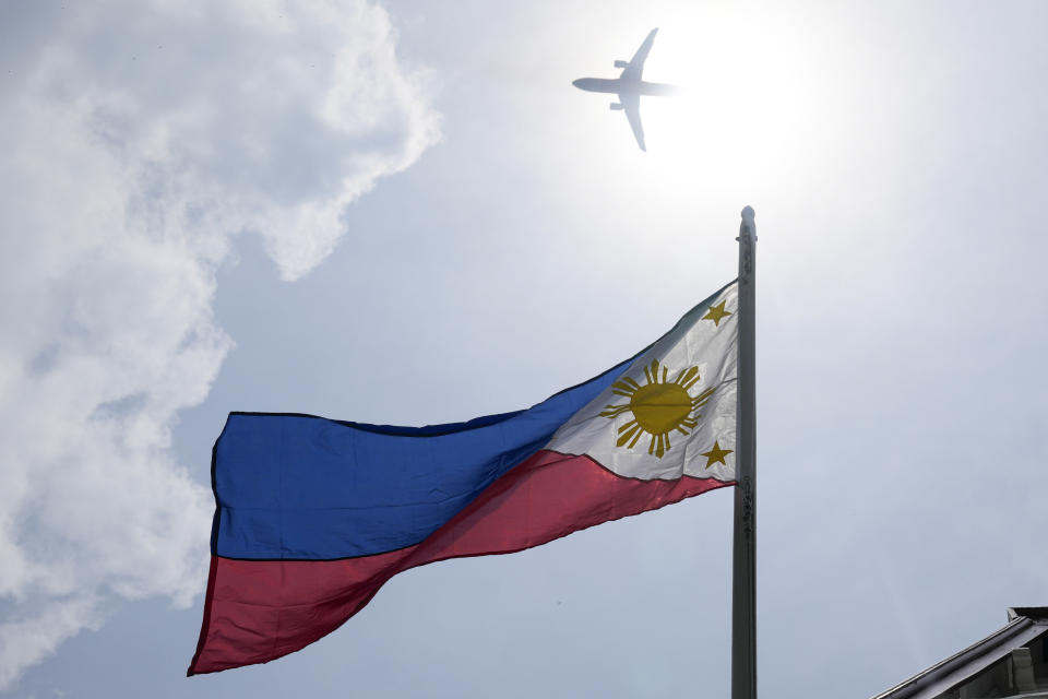 A plane flies above a Philippine flag at the Emilio Aguinaldo Shrine, where Philippine independence from Spain was proclaimed in Kawit, Cavite province, Philippines, Monday, June 10, 2024. The revelry surrounding Philippine Independence Day, which falls on June 12, stretches far beyond the Southeast Asia archipelago. Millions of Filipinos across major U.S. cities, as well as Europe, Australia, and even the United Arab Emirates, will be able to find parades, street fairs, galas, and other gatherings close to home. (AP Photo/Aaron Favila)