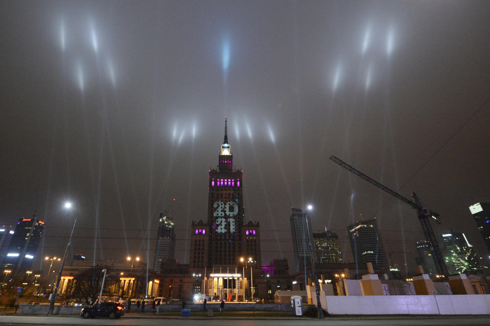 Light beams instead of traditional fireworks are seen around Warsaw's tallest building, The Palace of Culture and Science, greeted New Year under anti-COVID-19 restrictions in downtown Warsaw, Poland, Friday, Jan. 1, 2021.(AP Photo/Czarek Sokolowski)