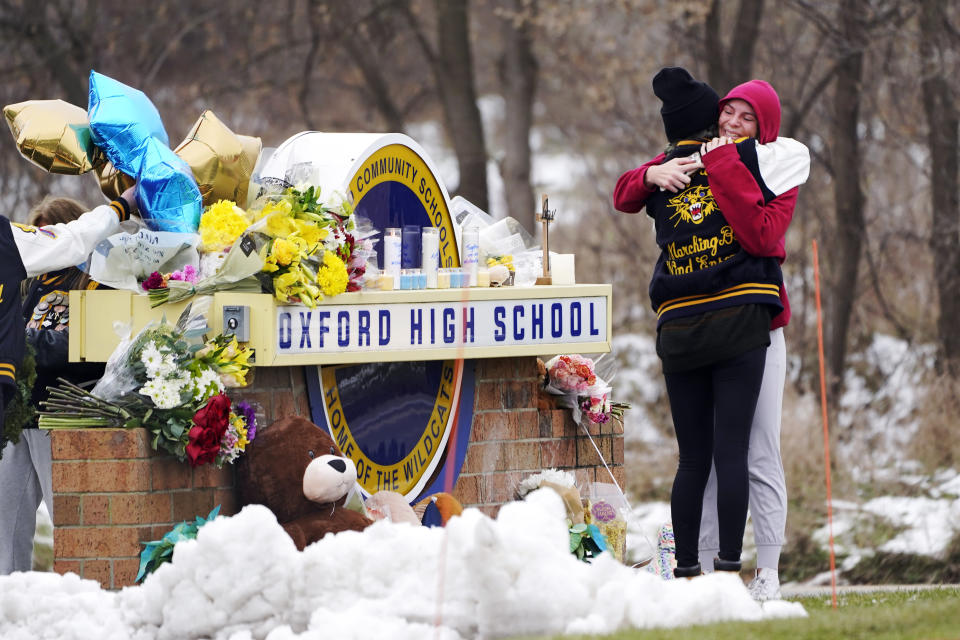 FILE - Students hug at a memorial outside of Oxford High School in Oxford, Mich., Dec. 1, 2021. An independent investigation report released Monday, Oct. 30, 2023 concluded that officials with Michigan’s Oxford High School should have conducted a threat assessment into Ethan Crumbley's behavior prior to a shooting that left four students dead and others wounded. (AP Photo/Paul Sancya, File)