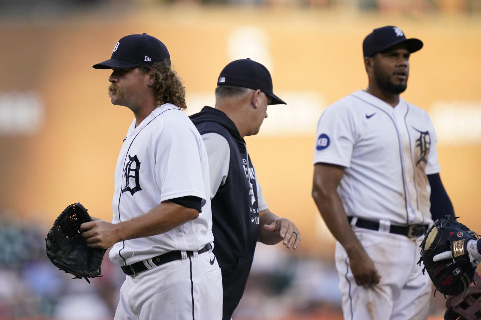 Detroit Tigers relief pitcher Andrew Chafin, left, walks to the dugout after being relived by manager A.J. Hinch, center, during the seventh inning of a baseball game against the Minnesota Twins, Saturday, July 23, 2022, in Detroit. (AP Photo/Carlos Osorio)