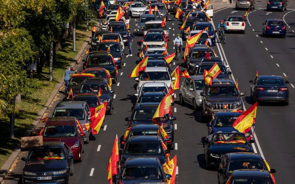 Demonstrators in Madrid protest against the national Government, which declared a state of emergency in the capital to restrict mobility - Getty