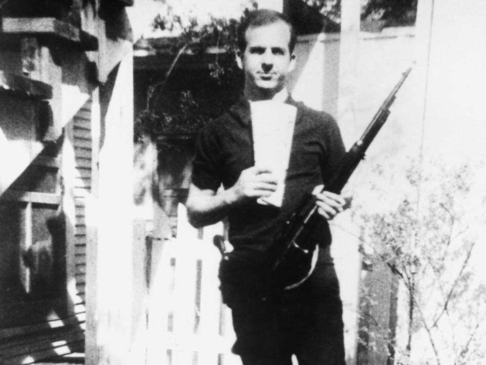 In this photo taken by his wife Marina, Lee Harvey Oswald poses with the Mannlicher–Carcano rifle he would later use to assassinate President John F Kennedy (National Archives)