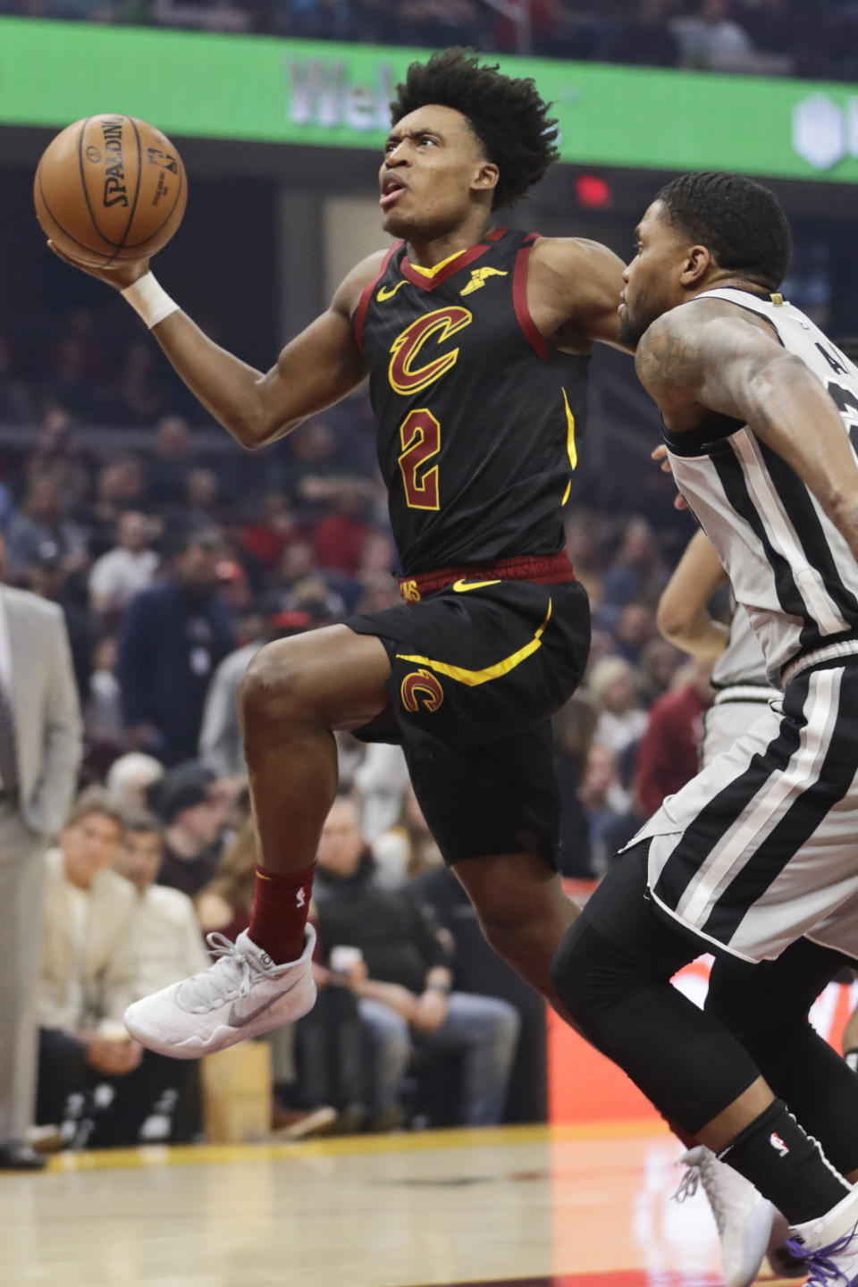 Cleveland Cavaliers' Collin Sexton, left, drives against San Antonio Spurs' Rudy Gay in the first half of an NBA basketball game, Sunday, March 8, 2020, in Cleveland. (AP Photo/Tony Dejak)