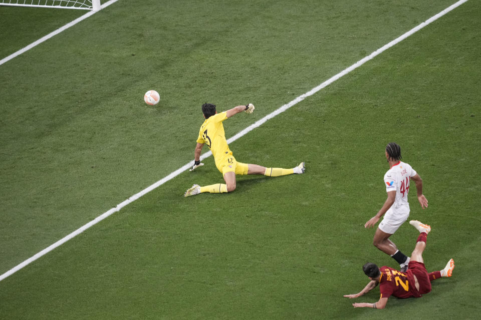 Roma's Paulo Dybala, bottom right, scores his side's opening goal during the Europa League final soccer match between Sevilla and Roma, at the Puskas Arena in Budapest, Hungary, Wednesday, May 31, 2023. (AP Photo/Darko Vojinovic)