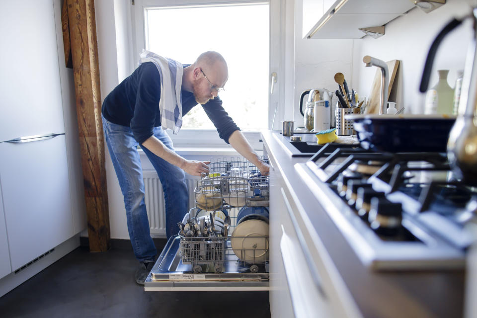 BERLIN, GERMANY - MARCH 26: Symbol photo on the subject of housework: A man puts away a dishwasher on March 26, 2020 in Berlin, Germany. (Photo by Thomas Trutschel/Photothek via Getty Images)