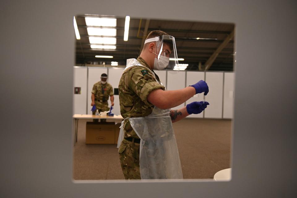 Soldiers wearing full PPE (personal protective equipment) process swabs from colleagues as they prepare for the arrival of members of the public inside the mass and rapid testing centre for the novel coronavirus COVID-19 at a Tennis centre in Liverpool on November 6, 2020. - To avoid extending the lockdown, Johnson is pinning his hopes on an ambitious new programme of Covid testing to detect and isolate infected people, starting with a city-wide trial launching in Liverpool today. (Photo by Oli SCARFF / AFP) (Photo by OLI SCARFF/AFP via Getty Images)