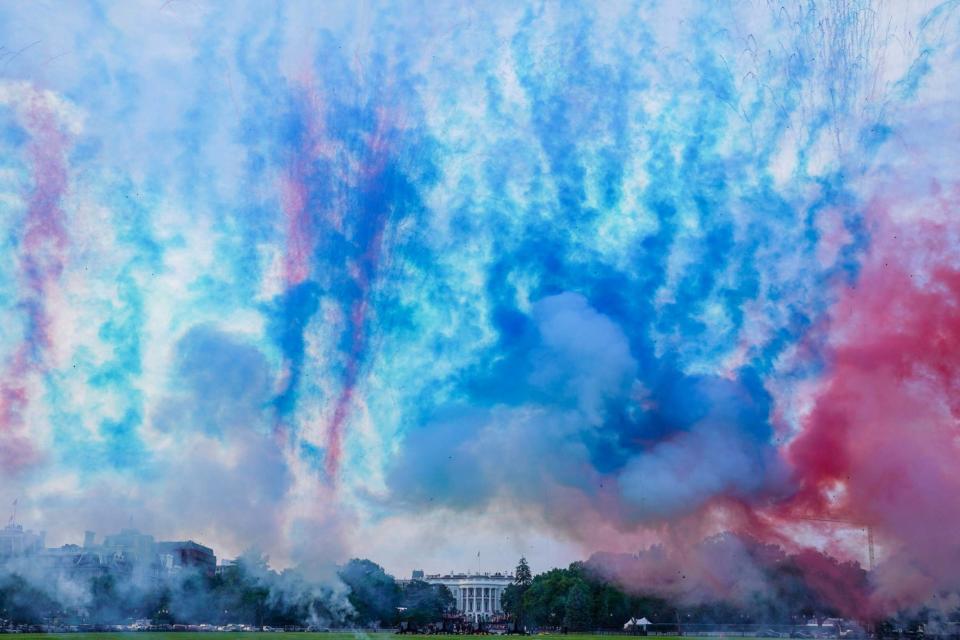 Red and blue smoke is fired at the Ellipse of the White House during the 'Salute to America' (REUTERS)