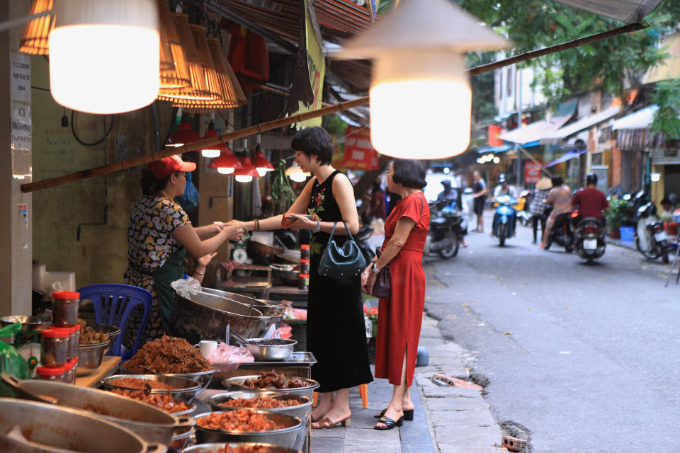 People shop for food in a market in Hanoi, Vietnam on Sunday, Aug. 14, 2022. In the six months since Russia invaded Ukraine, the fallout from the war has had huge effects on the global economy. Though intertwined with other forces, the war has made problems like inflation much worse for people around the world. Soaring food and energy prices have turned into crises that are threatening to plunge millions of people into poverty and make recessions ever more likely. (AP Photo/Hau Dinh)