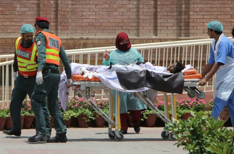 Rescue workers and paramedics bring a burns victim injured when an oil tanker caught fire following an accident on a highway in central Pakistan to a hospital in Multan on June 25, 2017