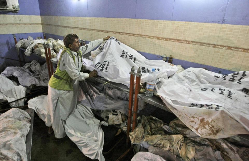 In this Friday, Oct. 19, 2012 photo, the bodies of Pakistanis who were killed in a fire at a garment factory last September, remain unidentified at a Morgue in Karachi, Pakistan. At the only morgue in Pakistan's largest city lie the blackened remains of 32 people killed in one of the worst industrial accidents in the country's history, wrapped in white plastic body bags waiting for DNA tests to determine who they are and where they belong. (AP Photo/Fareed Khan)