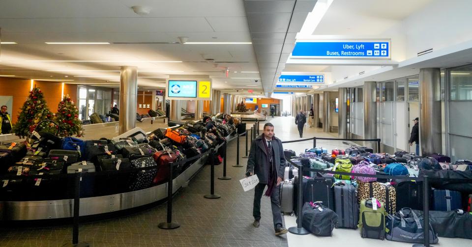 Juan Diaz walks through the vast amount of Southwest luggage after delays and cancellations during the Christmas holiday Tuesday, Dec. 27, 2022, at Milwaukee Mitchell International Airport.