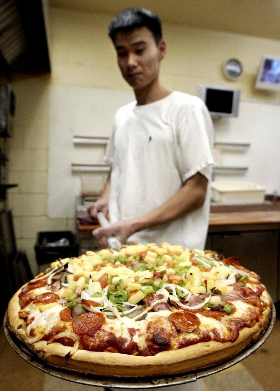 Kevin Mitchell pulls a pizza out of the oven at DeLuca's in 2005.