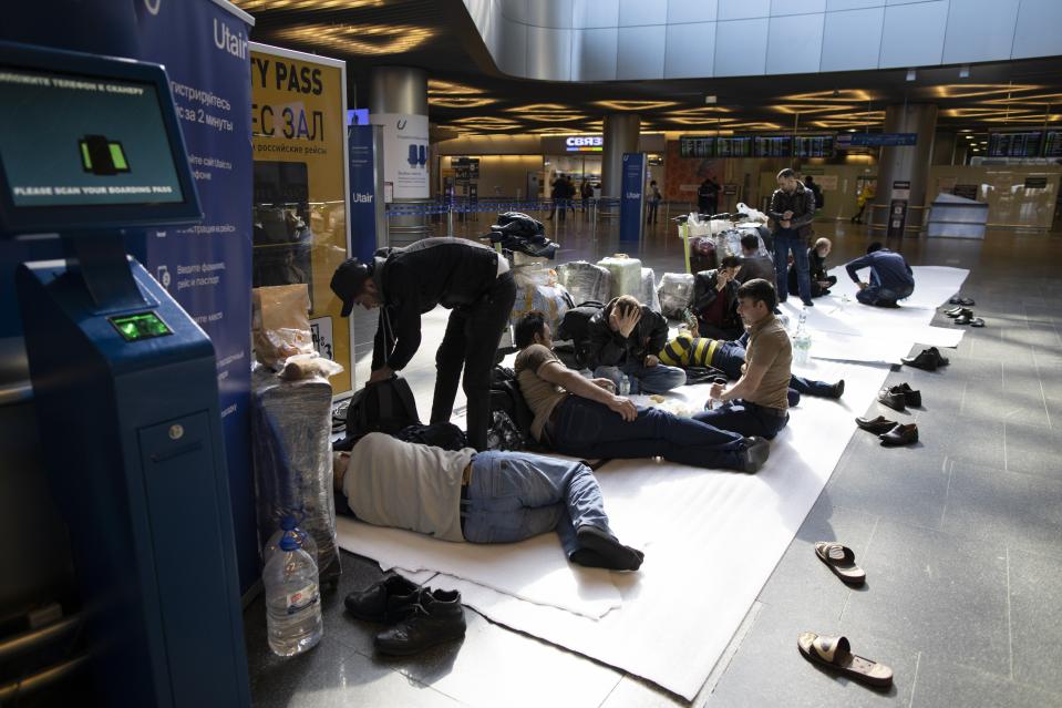 Tajikistan residents rest on the floor while waiting for a plane to their home country at the Vnukovo international airport in Russia amid the virus pandemic. Source: AAP