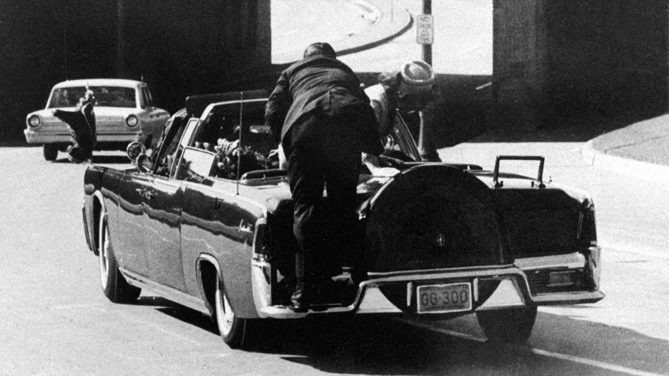 President John F. Kennedy slumps down in the back seat of the presidential limousine after being fatally shot in Dallas on November 22, 1963. Mrs. Jacqueline Kennedy leans over the president as Secret Service agent Clinton Hill rides on the back of the car. - Ike Altgens/AP