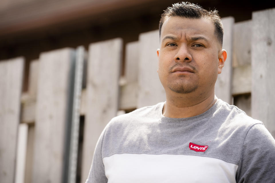 Fidel Martinez stands for a portrait at one of his former worksites in Minneapolis on Sunday, April 18, 2021. Martinez worked for a demolition contractor in the fall of 2020, demolishing several Walgreens stores and other structures. Martinez said the contractor owed him and his co-workers more than $20,000. His boss kept telling him the money was coming, but he would get his paychecks weeks late, and many of them he didn't get at all. (AP Photo/John Minchillo)