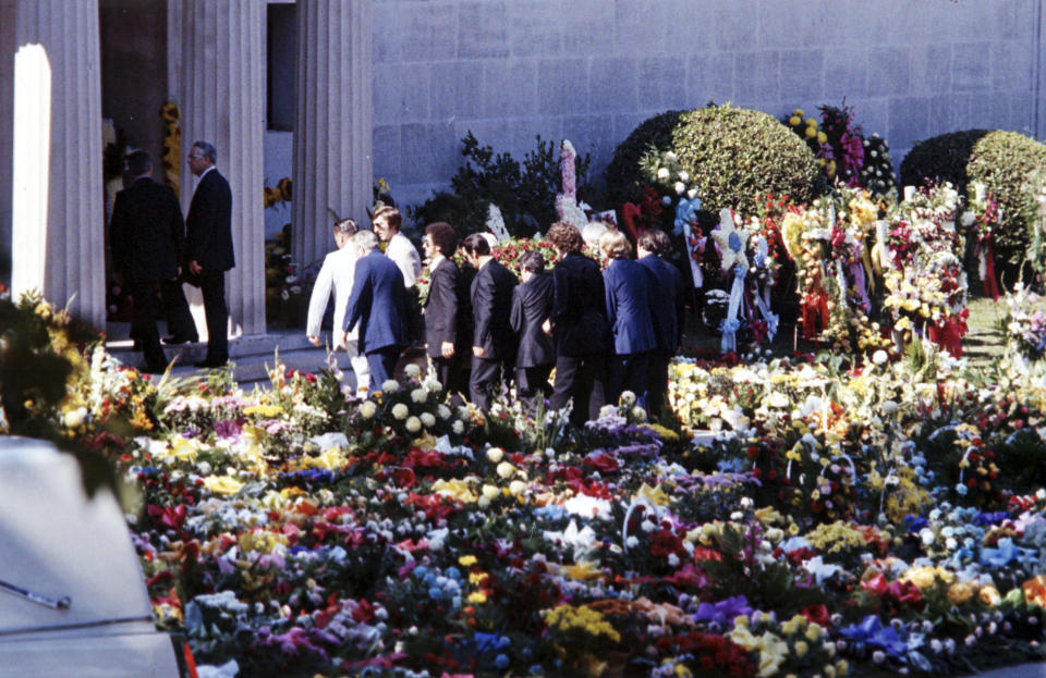 FILE - In this Aug 18, 1977 file photo, pallbearers carry the flower-covered coffin of Elvis Presley into the Forest Hills Cemeteries mausoleum in Memphis, Tenn. After a thief tried to snatch his body, the remains of both Elvis and his mother were moved to a garden at Graceland. (AP Photo, File)