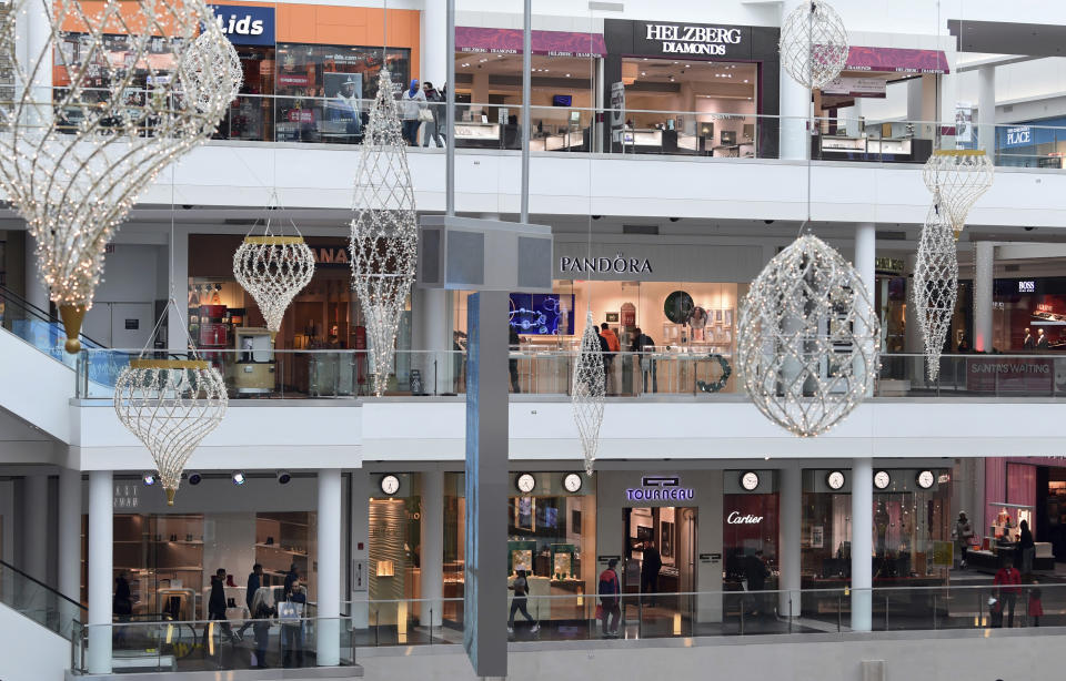 FILE - In this Dec. 22, 2017, file photo people shop at the Pentagon City Mall in Arlington, Va. Clothing retailers, particularly those in malls, have been devastated by changing consumer behavior. More than 9,000 stores were shuttered last year. (AP Photo/Susan Walsh, File)