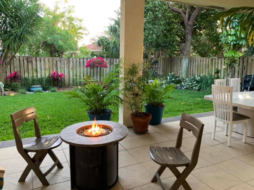 The backyard of the Connie House features a fire pit, dining table, grill, refrigerator and plenty of room for gardening and other activities.