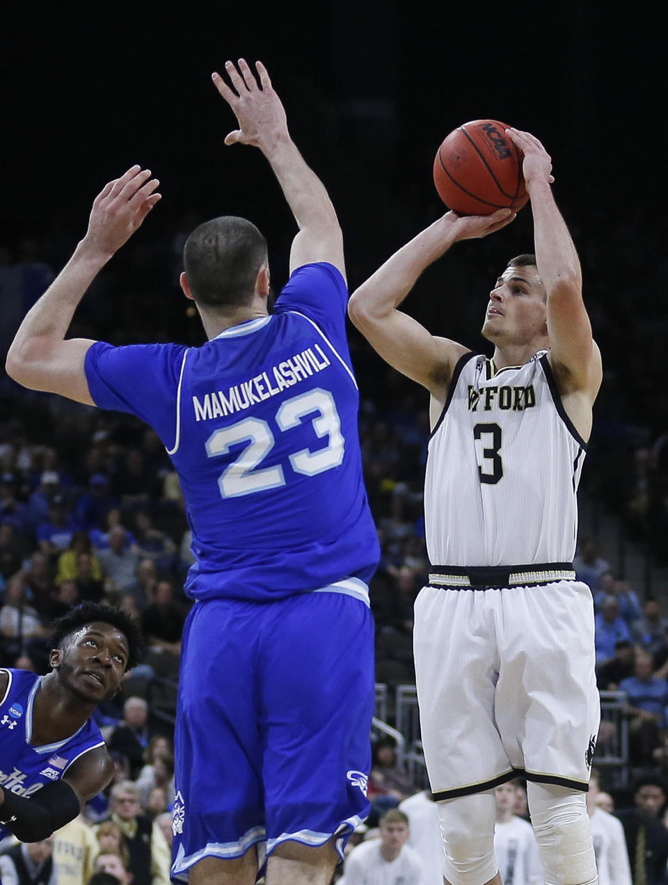 Wofford's Fletcher Magee (3) takes a 3-point shot over Seton Hall's Sandro Mamukelashvili (23) during the first half of a first-round game in the NCAA men’s college basketball tournament in Jacksonville, Fla., Thursday, March 21, 2019. (AP Photo/Stephen B. Morton)