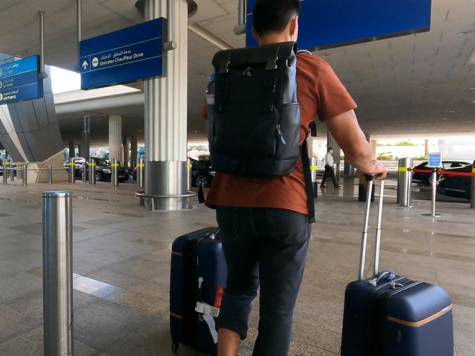 Man standing with luggage outside of airport