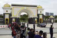 Police salute to Sultan of Perlis, inside a black car, as the convoy arriving National Palace in Kuala Lumpur, Malaysia, Sunday, Oct. 25, 2020. Malay rulers hold a special meeting on Sunday to discuss the government's plan to declare an emergency to tackle the worsening COVID-19 situation. (AP Photo/Vincent Thian)