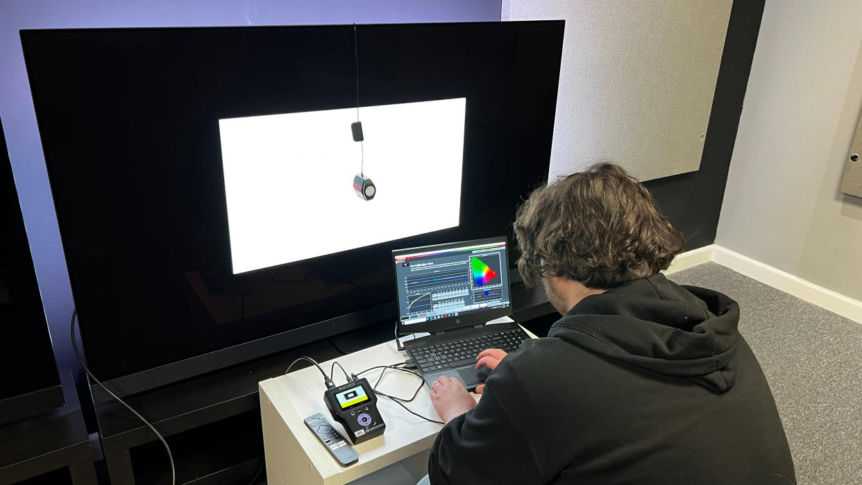  TechRadar reviewer measuring TV accuracy with test equipment. 
