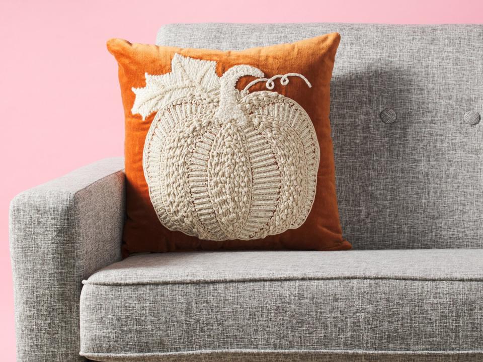 pumpkin pillow on gray sofa from HomeGoods new online store